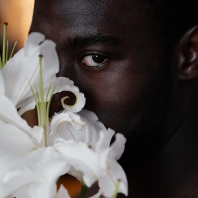 homme qui se cache derrière des fleurs blanches